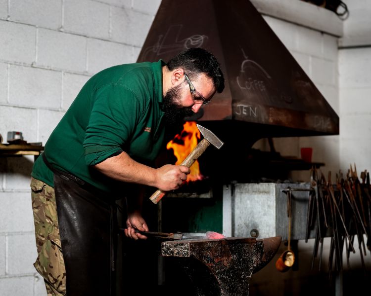 man shaping knife on blacksmith experience in peak district