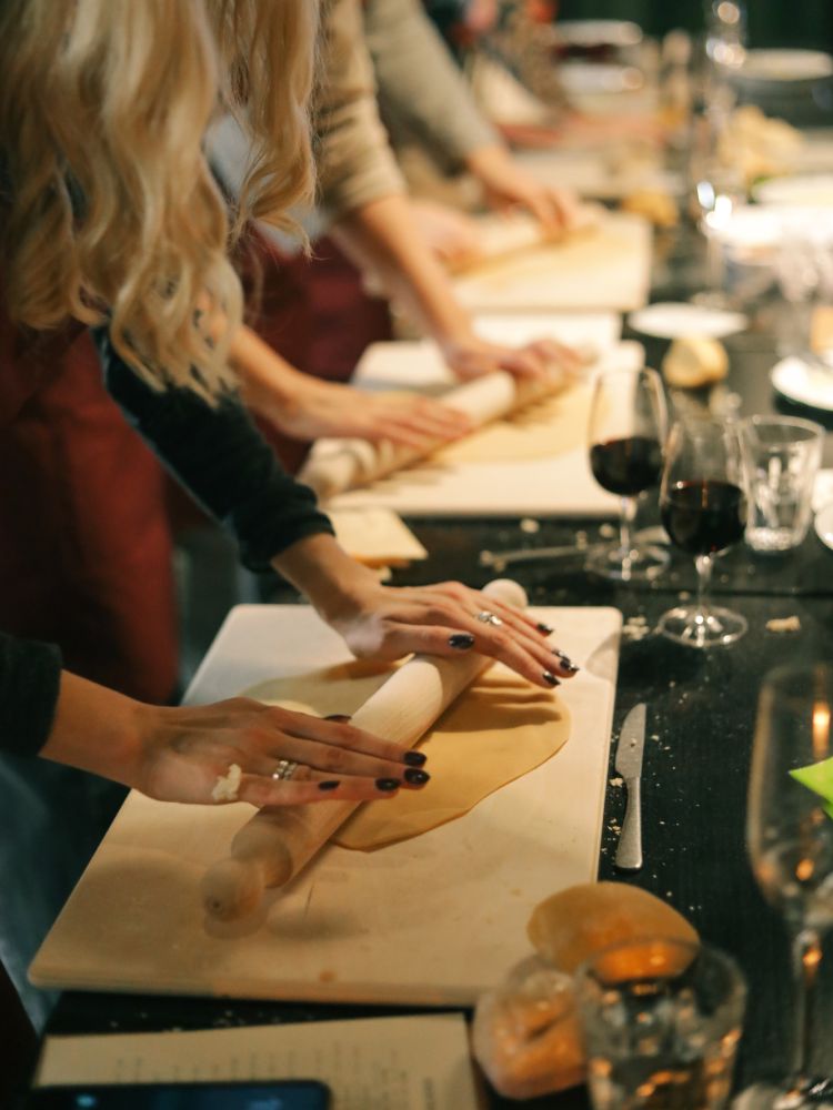 Students rolling pasta dough at pasta making class