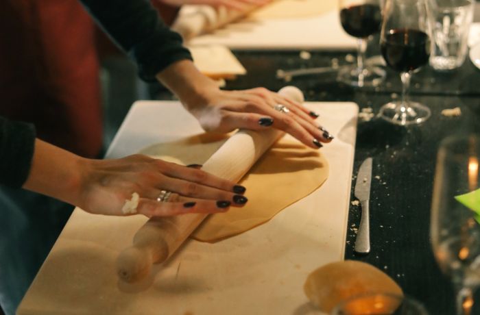 Students rolling pasta dough at pasta making class