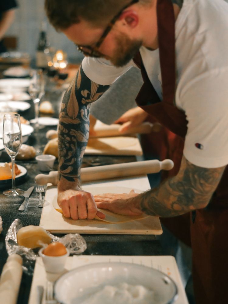 Man stretching pasta dough at pasta making class