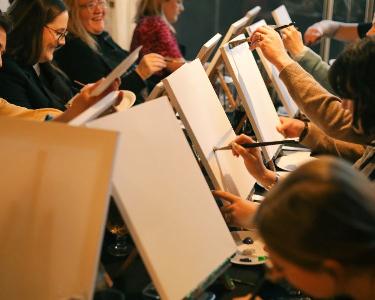 People painting at a paint and prosecco event