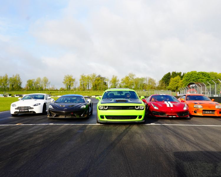 Five supercars lined up on a race track