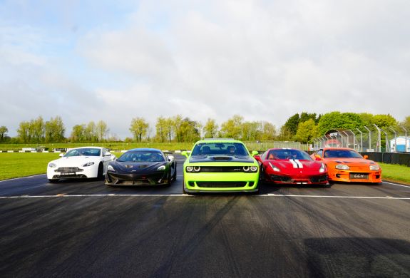 Five supercars lined up on a race track