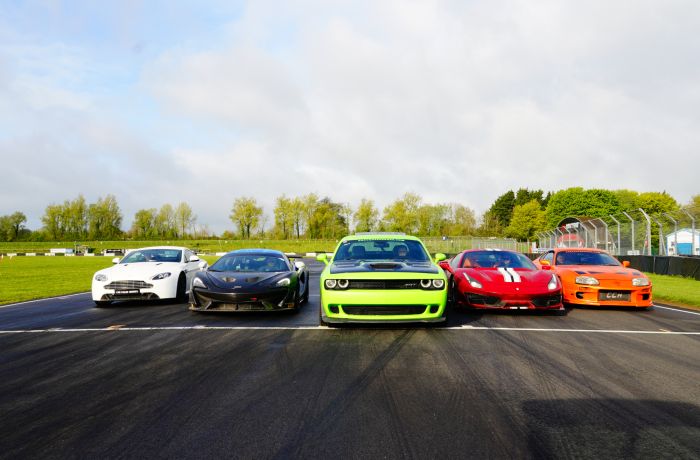 Five supercars lined up on a race track