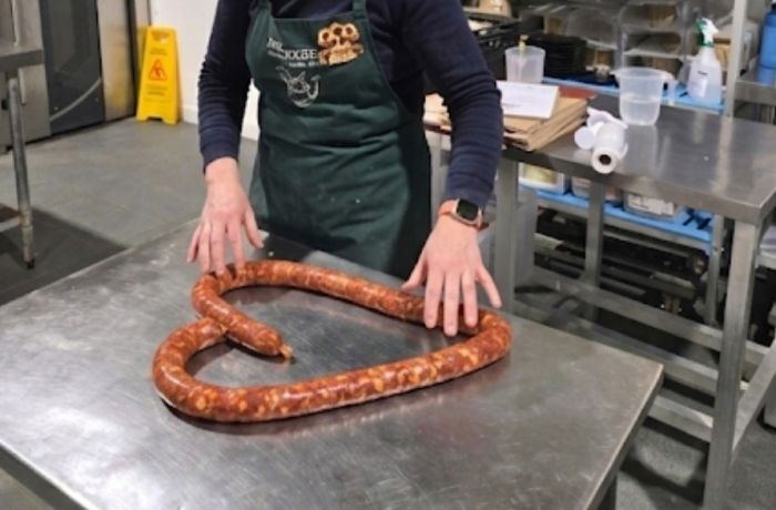 woman with handmade continental sausage shaped into a heart