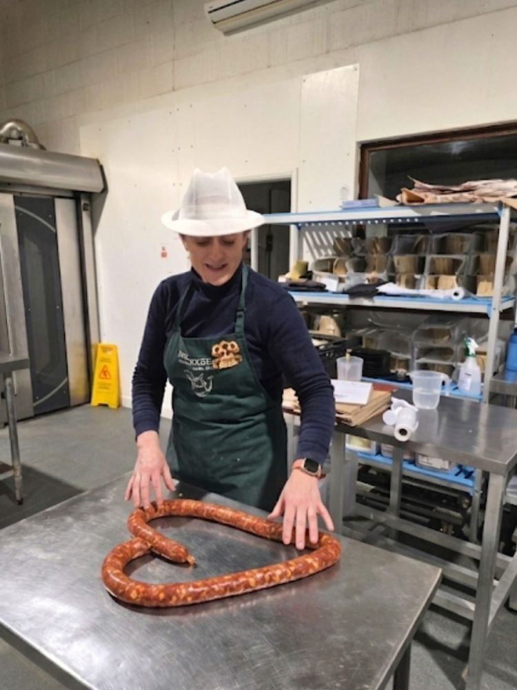 woman with handmade continental sausage shaped into a heart