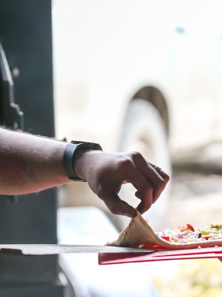 pizza going into the wood-fired oven on a pizza making workshop