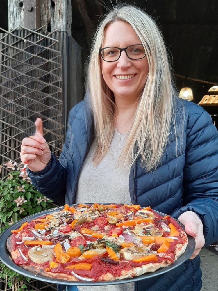 lady with her wood-fired pizza make on a pizza making workshop