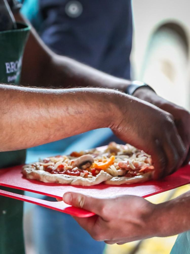 preparing to lay the pizza on a board ready to cook in wood-fired oven