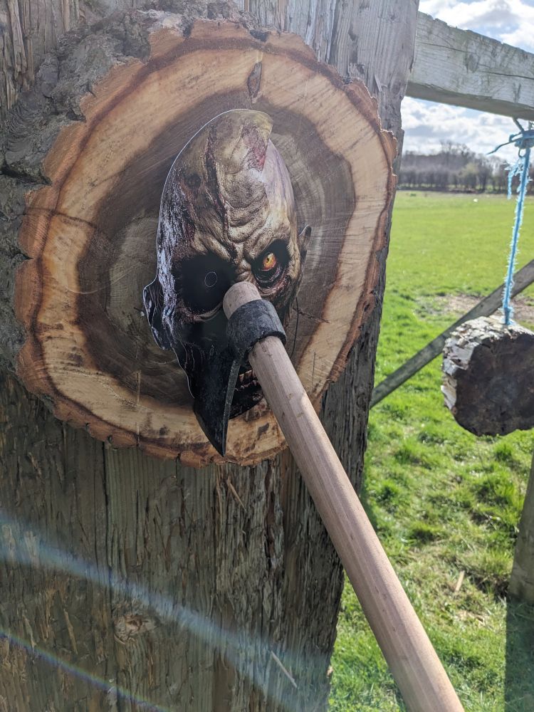 a zombie head target with an axe stuck in it
