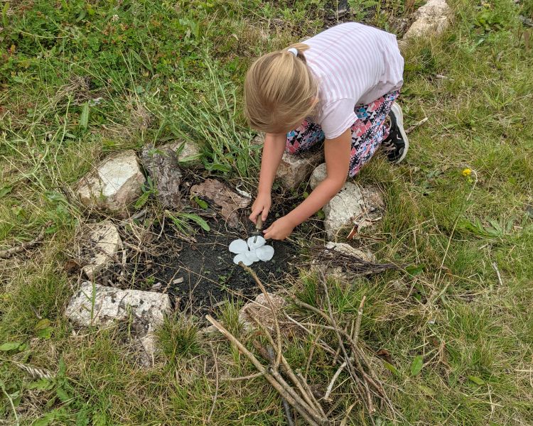 girl making a campfire on a bushcraft experience
