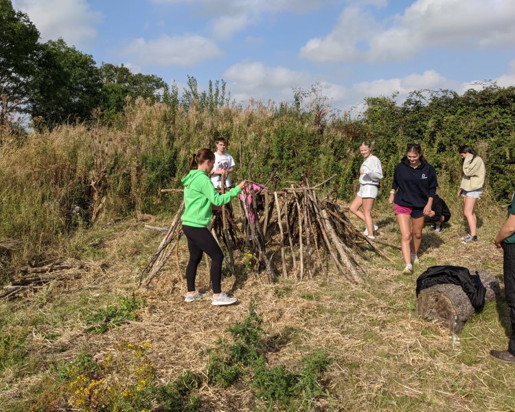group collecting sticks to make a den on a bushcraft experience