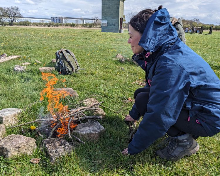 woman lighting a fire on a bushcraft experience