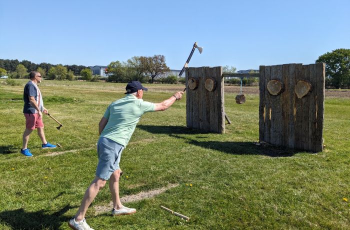 man throwing an axe at a wooden target on an axe throwing experience