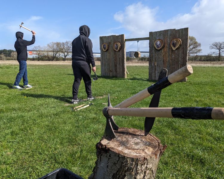 two people throwing axes at targets on an axe throwing experience