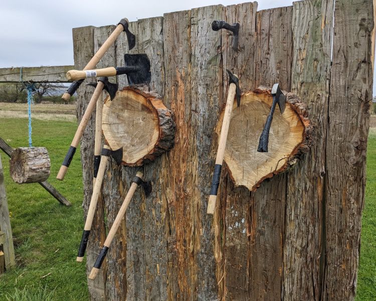 axes stuck in wooden targets on an axe throwing experience