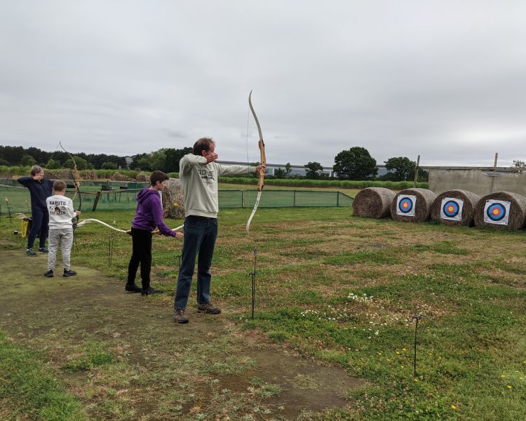 three people shooting arrows at targets on a robin hood weapons experience