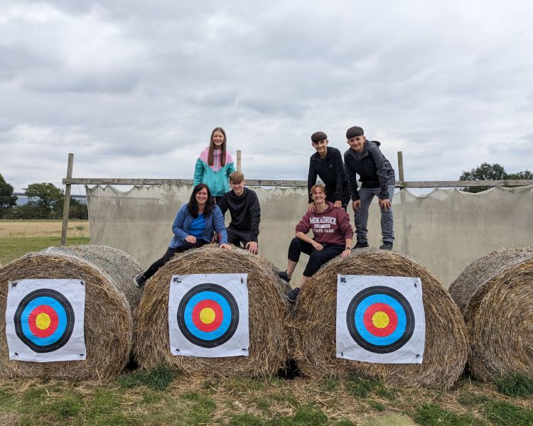 people on top of hay bales that have archery targets on