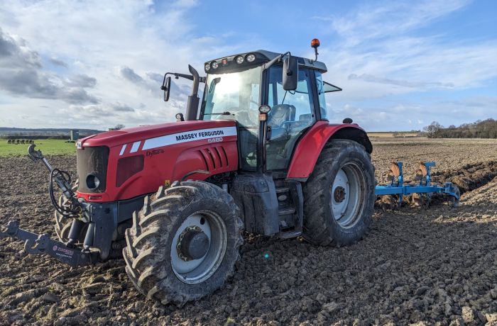 tractor in a field with plough behind on a tractor driving experience