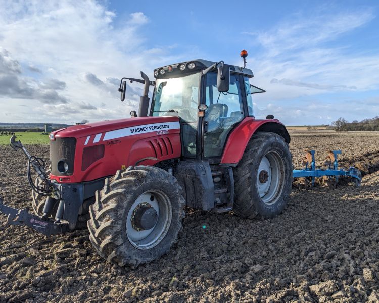 tractor in a field with plough behind on a tractor driving experience