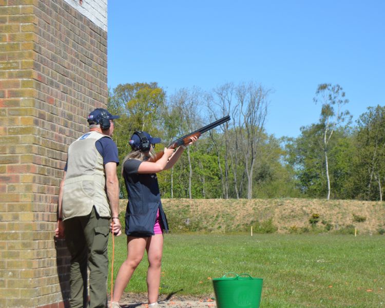 A woman and instructor clay pigeon shooting