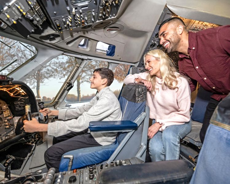 family visiting brooklands museum looking at inside of plane