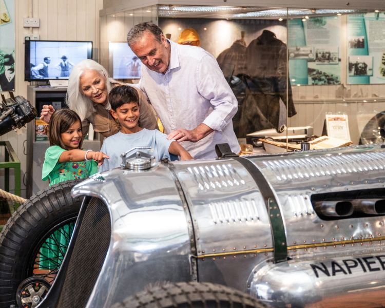 Kids and grandparents looking at vintage cars at brooklands museum