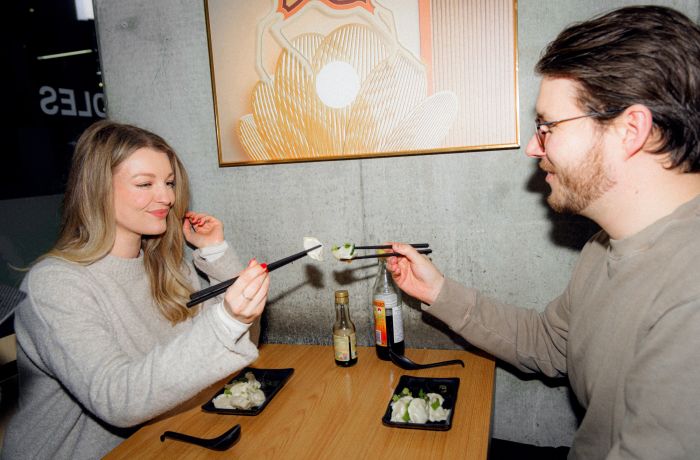Couple eating dumplings in restaurant on food treasure hunt in manchester