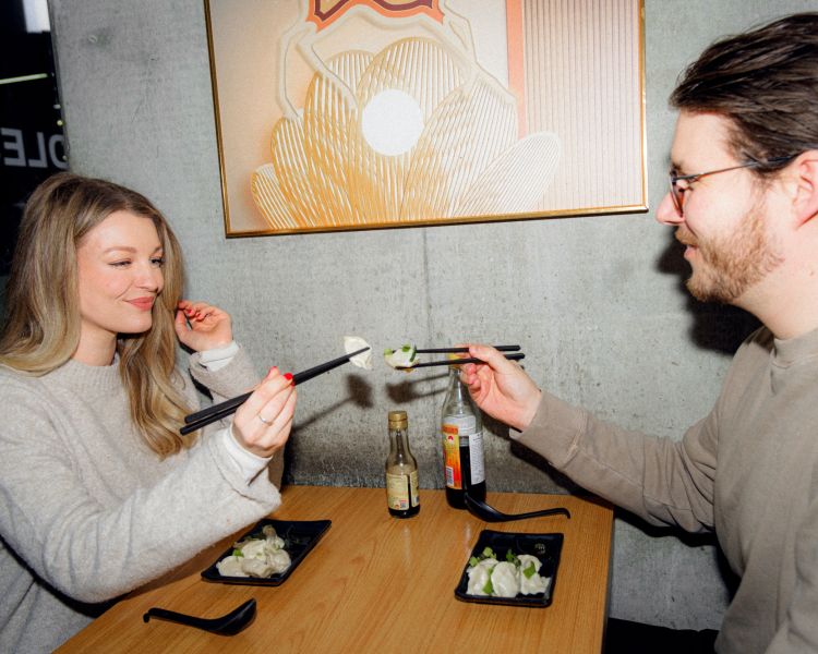 Couple eating dumplings in restaurant on food treasure hunt in manchester
