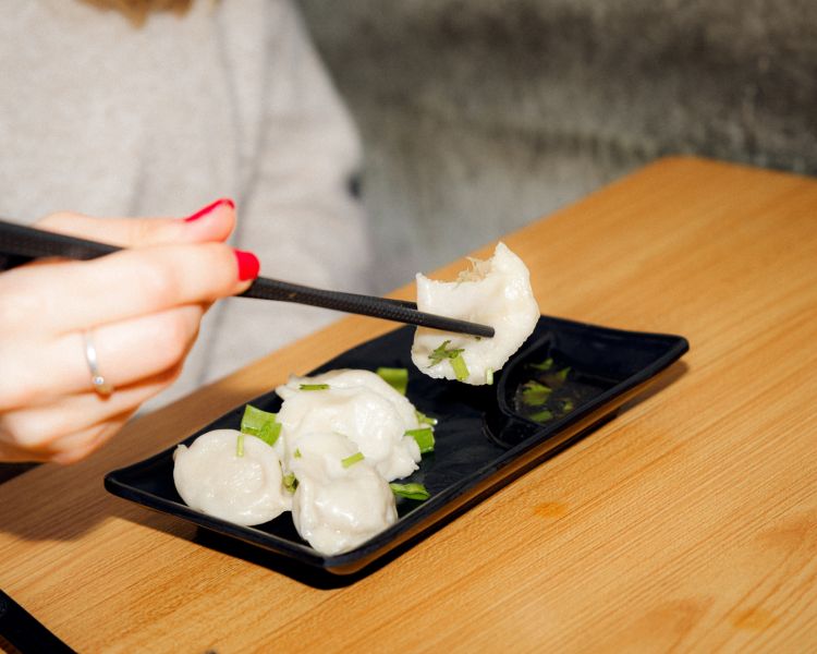 Eating dumplings with chopsticks on food treasure hunt in manchester