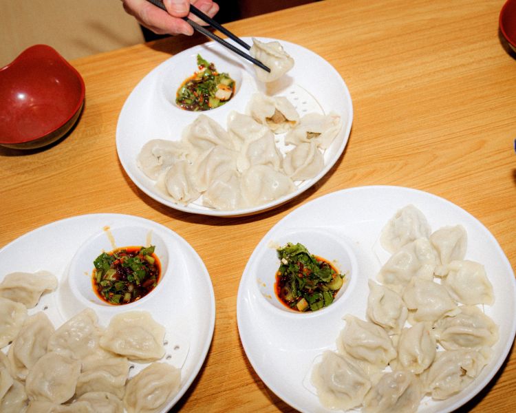 Three plates of dumplings with dipping sauce on food treasure hunt in manchester