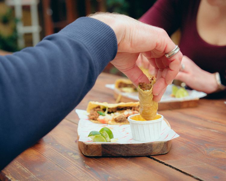 Dipping taco in sauce on food treasure hunt in manchester
