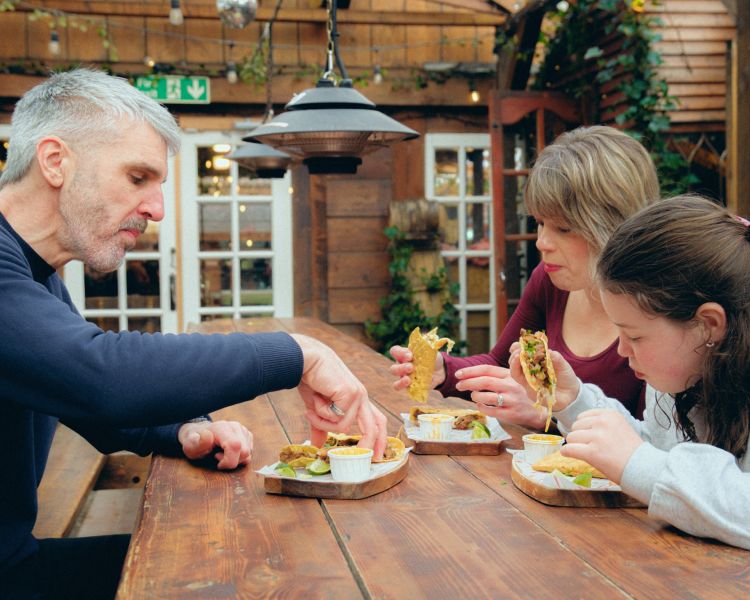 Family eating tacos on food treasure hunt in manchester