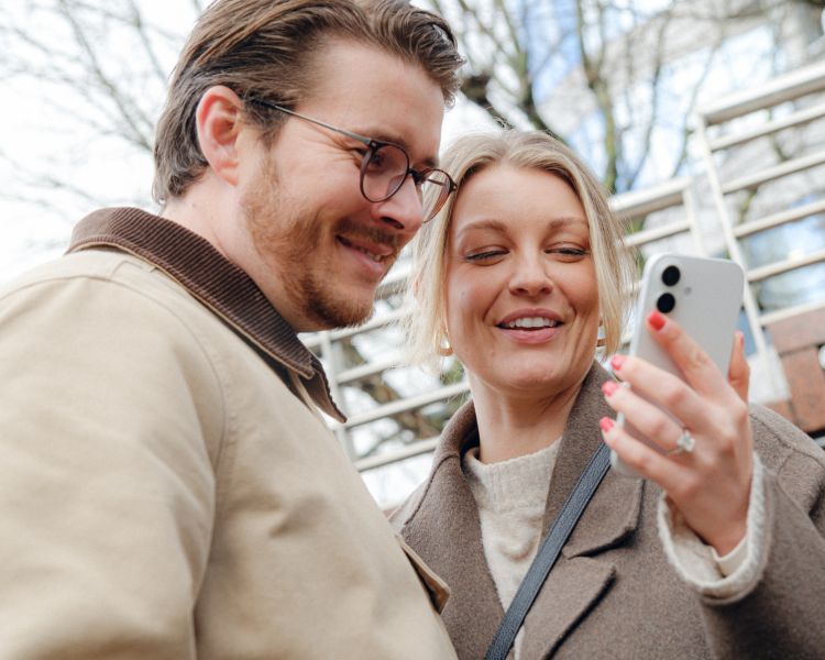 Couple looking at phone on food treasure hunt in manchester
