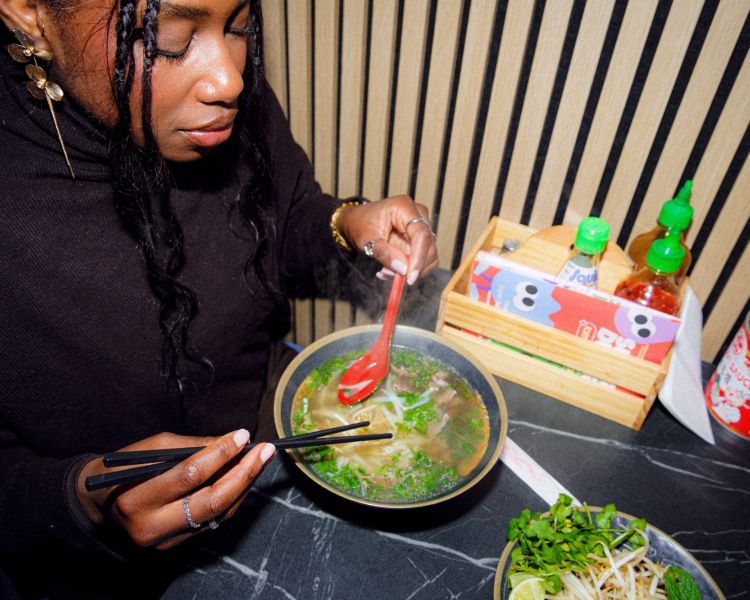 Woman eating ramen on food treasure hunt in manchester