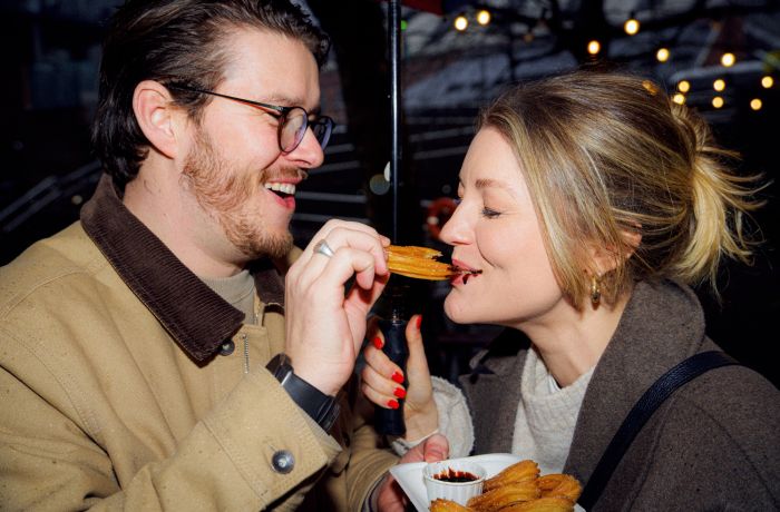Couple eating churros on a food treasure hunt in manchester
