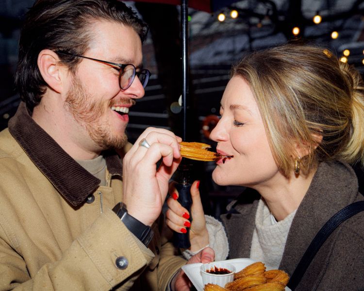Couple eating churros on a food treasure hunt in manchester