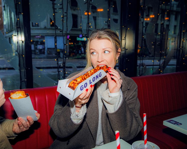 Woman eating pizza on a food treasure hunt in manchester
