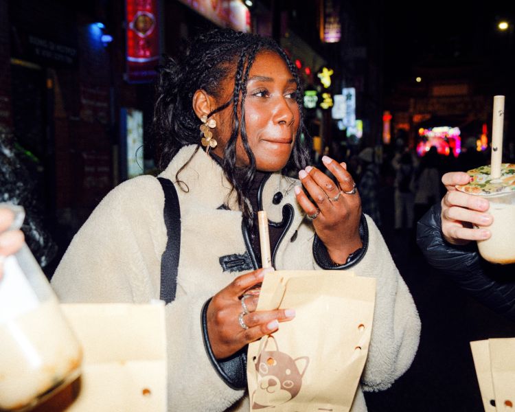 Friends eating cake and drinking bubble tea on a food treasure hunt in manchester