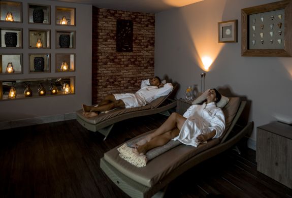 A couple lounging in spa robes