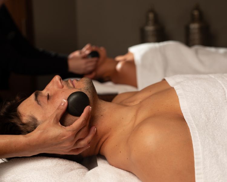 Close up of a man couples hot stone treatment