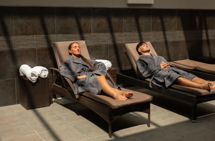 A man and woman lounging in spa robes