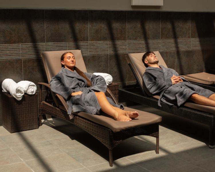 A man and woman lounging in spa robes