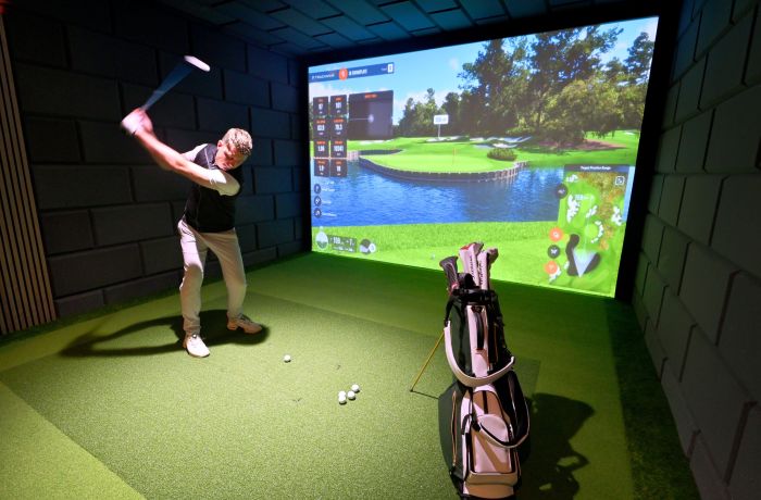 A man on an indoor golf simulator