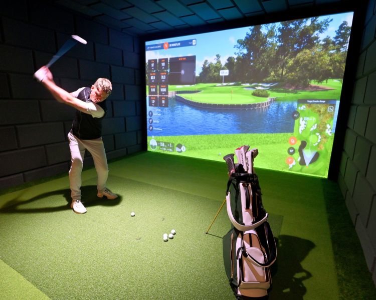 A man on an indoor golf simulator