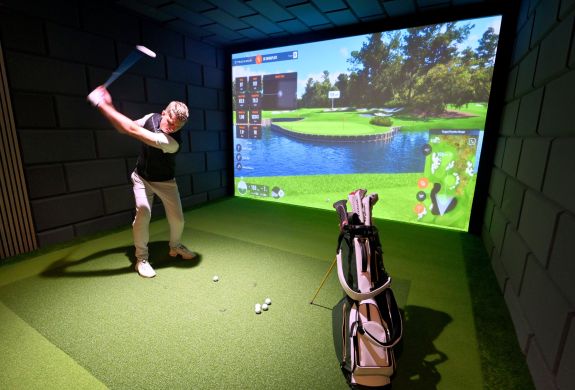 A man on an indoor golf simulator