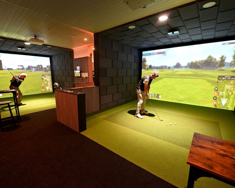 Two men on indoor golf simulators