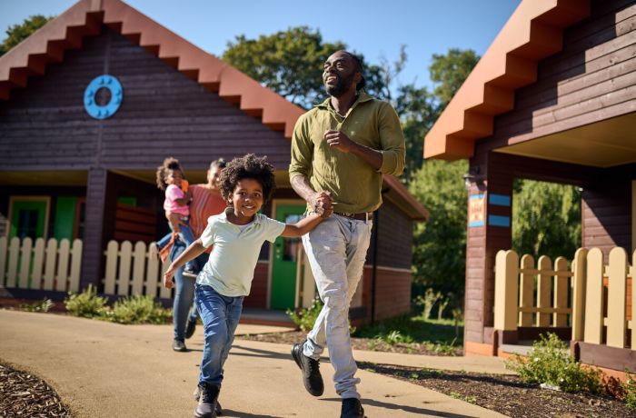 family running out of a woodland lodge at legoland windsor