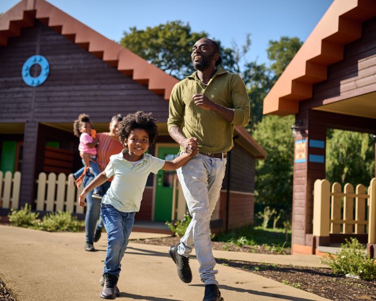 family running out of a woodland lodge at legoland windsor