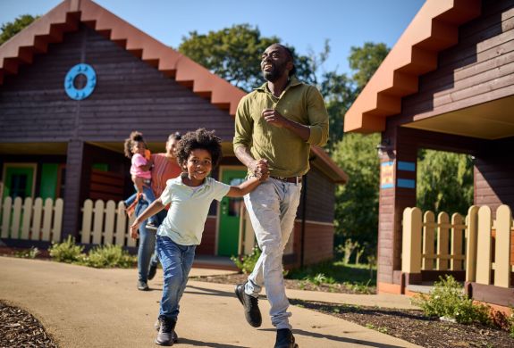 family running out of a woodland lodge at legoland windsor